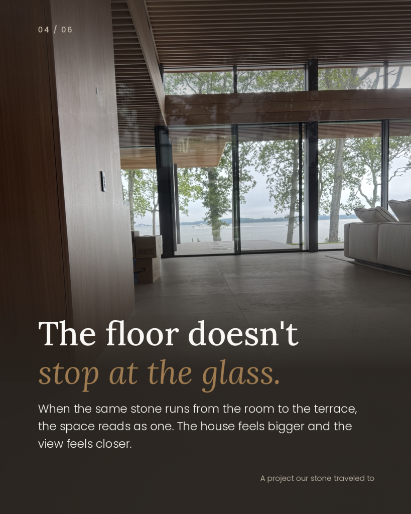 One Stone Inside and Out: Using the Same Natural Stone for Interior Floors and Outdoor Living 4 Interior natural stone floor continuing through floor-to-ceiling glass doors to an outdoor terrace overlooking the water.